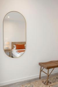 uno specchio in una camera da letto con un letto e un tavolo di Casa LukStian a Nazaré Altre 23 foto