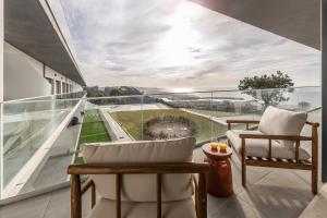 un balcone con due sedie e una grande finestra di Casa LukStian a Nazaré