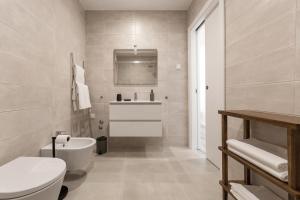 a bathroom with a white toilet and a sink at Casa LukStian in Nazaré +21 photos