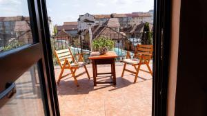 a patio with a table and chairs on a balcony at Popas Făgărășan in Făgăraş