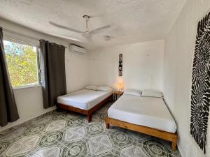 ein Zimmer mit zwei Betten und einem Fenster in der Unterkunft Centrally located apartment 2 blocks from the sea in Cozumel