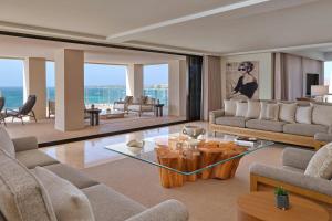 a living room with couches and a table at The St. Regis Aruba Resort in Palm-Eagle Beach