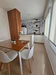 a kitchen with a wooden table and white chairs at Departamento 12 Tower in Salta