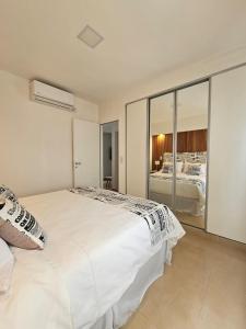 a bedroom with a large white bed and a mirror at Departamento 12 Tower in Salta +15 photos