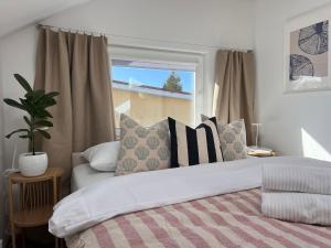 a bedroom with a bed with pillows and a window at Kapitan S in Gdańsk