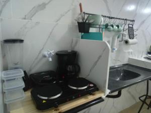 a small kitchen with a stove and a sink at Kitnet de luxo perto do shopping da ilha in São Luís