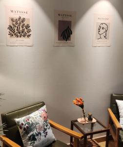 Zimmer mit 2 Stühlen und einem Tisch mit einer Blumenvase in der Unterkunft Green Bring in Daegu