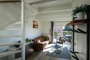 a living room with a couch and a table at Friese Antillen in Hollum