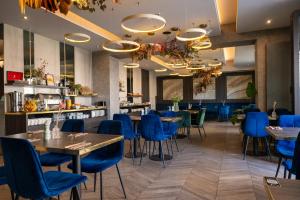 a restaurant with blue chairs and tables at Hotel Atrium in Krakow