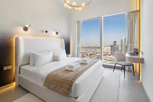a bedroom with a white bed and a large window at Bella Elite Homes at Grande Signature Burj and Fountain Best View- Brand New Luxury Apartment in Dubai +37 photos