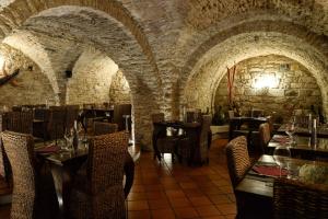 a restaurant with stone walls and tables and chairs at Perbacco in SantʼAngelo Limosano