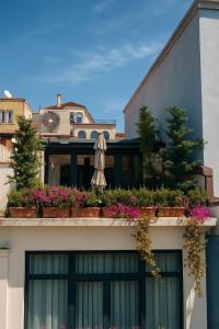 a building with a balcony with flowers and an umbrella at AB Residences- Private Villa Independent in Istanbul