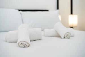 una pila de toallas enrolladas sobre una cama en Charming 3BR by Redcliffe Gdns, en Londres