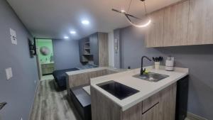 Una cocina con fregadero y una sala de estar. en Casa 1982, en Manizales