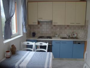 a kitchen with blue cabinets and a table and chairs at Blue Lagoon Pag in Pag +8 photos