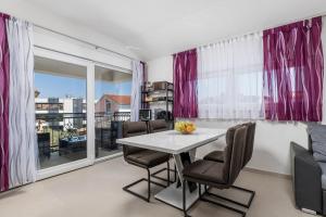a dining room with pink curtains and a table and chairs at Adults only Guesthouse Villa Samantha by Irundo in Rovinj