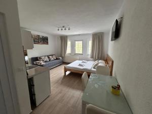 a kitchen and living room with a table and a couch at Apartmani Waterfall / Vodopad in Jajce