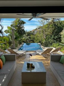 Una sala de estar con una mesa y una piscina. en Wild Palms, en Ban Tai