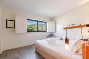 una camera da letto con un letto e una finestra di Stone by the Sea - Mountain & Beach Retreat w/Pool a Viana do Castelo