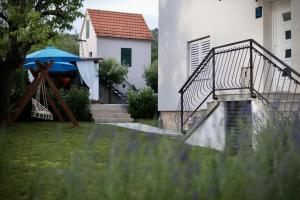 a staircase leading to a house with a blue umbrella at Villa Hedera in Drniš