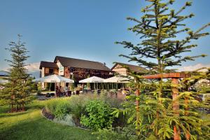 a restaurant with tables and umbrellas in a garden at Hilson Jasna - Garden resort in Liptovský Mikuláš