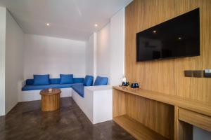a living room with a blue couch and a flat screen tv at Sunset Paradise Canggu in Canggu