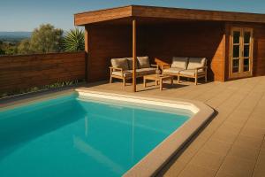 a swimming pool with two chairs and a table at Torre Costa Brava Private pool in Garrigás