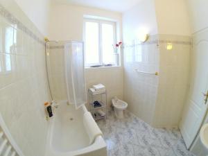 biała łazienka z prysznicem i toaletą w obiekcie Villa Sonnenstrahl w Mariańskich Łaźniach +37 zdjęć