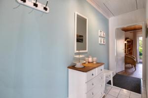 a bathroom with a white dresser and a mirror at Ferienwohnung Martina in Leck +19 photos