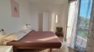 a bedroom with a large bed and a window at Eco House San Michele in San Michele