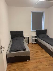ein Schlafzimmer mit zwei Betten und einem Fenster in der Unterkunft Modernes Wohnerlebnis in bester Lage in Heilbronn
