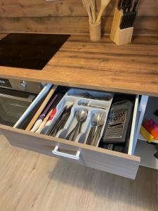 eine Schublade mit Geschirr in einem Holzschrank in der Unterkunft Modernes Wohnerlebnis in bester Lage in Heilbronn