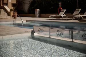 una piscina con sedie a sdraio in un edificio di Apartamentos Isla Del Sol a Can Pastilla
