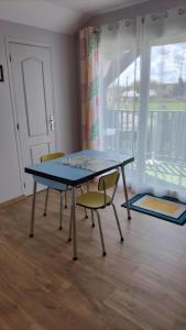 stół i krzesła w pokoju z oknem w obiekcie Appartement Vallée de la Risle w mieście Glos-sur-Risle