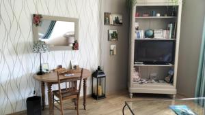 salon ze stołem i lustrem w obiekcie Appartement Vallée de la Risle w mieście Glos-sur-Risle