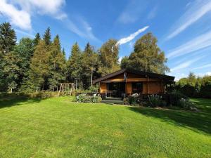 a cabin in the middle of a grass field at Private Swedish Forest Cabin in Ulricehamn