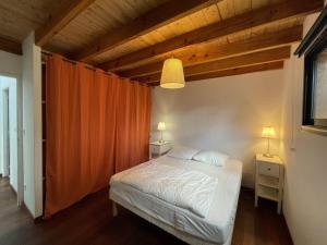 a bedroom with a white bed and two night stands at Villa 8 pers. Soustons proche lac, océan et golf, WiFi, animaux admis, parking - FR-1-379-83 in Soustons