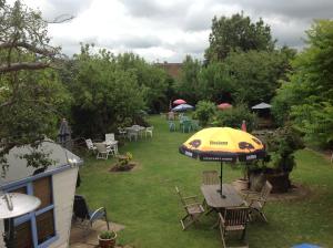 a patio with an umbrella and chairs and tables at The Beaufort Hunt in Chipping Sodbury
