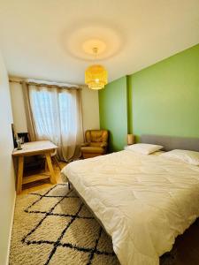 a bedroom with a bed and a table and a chair at Le Molay in Beaune
