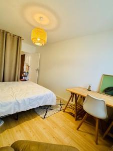 a bedroom with a bed and a desk and a table at Le Molay in Beaune