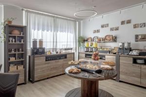 a large kitchen with a table with pastries on it at Best Western Hotel Residence Italia in Quartu SantʼElena