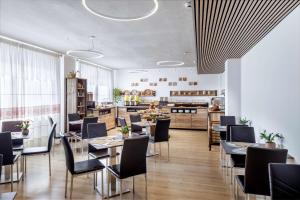 a restaurant with tables and chairs and a kitchen at Best Western Hotel Residence Italia in Quartu SantʼElena