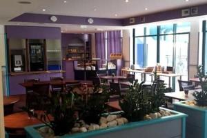 a restaurant with tables and chairs and plants at Studio dans une residence hoteliere avec piscine couverte in La Rochelle