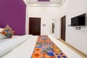 a bedroom with a bed and a tv on a wall at Via Awadh Royal in Ayodhya
