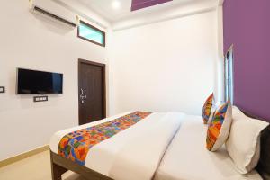 a bedroom with a bed and a tv on a wall at Via Awadh Royal in Ayodhya