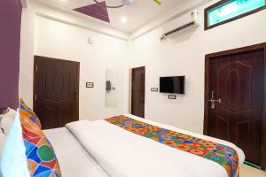 a bedroom with a bed and a tv on the wall at Via Awadh Royal in Ayodhya