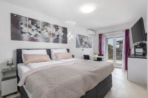 a bedroom with a large bed and a tv at Adults only Guesthouse Villa Samantha by Irundo in Rovinj