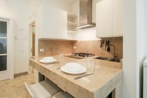 a kitchen with white cabinets and a counter top at iPanema in Rimini +9 photos