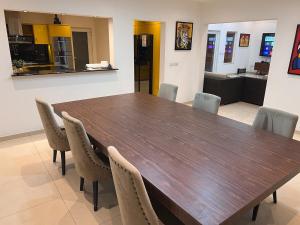 Ban Nong ChaengにあるPattaya Serenity Oasis 8BR Pool Villa for Great Vacationsの大きな木製テーブルと椅子が備わります。