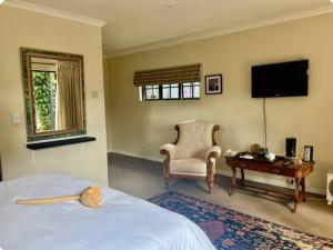 a bedroom with a bed and a chair and a desk at The Midlands Protea in Howick